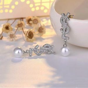 Stainless steel YSL shaped diamond needle earrings with imitation pearl.